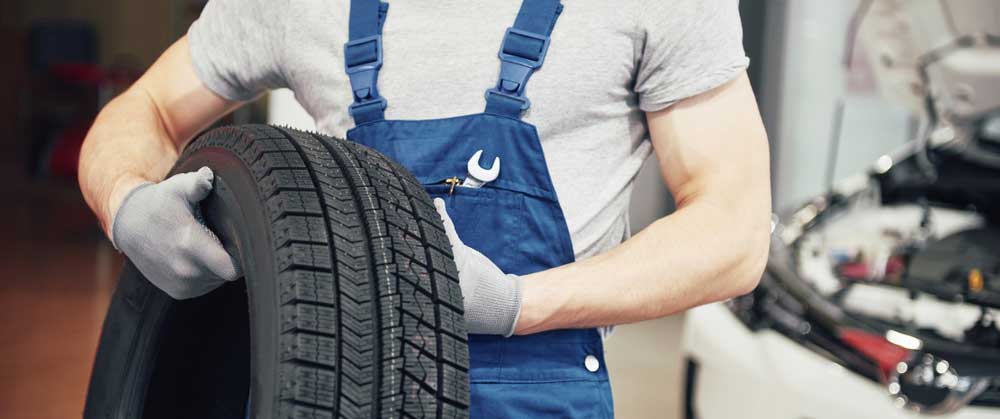 A employee holding a tire to Improve Employee Retention in the Auto Industry