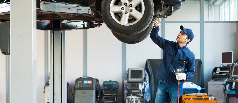 An employee checking tires of a car in the auto shop.