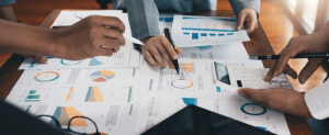 Hands are shown while working on the paper charts and graphs