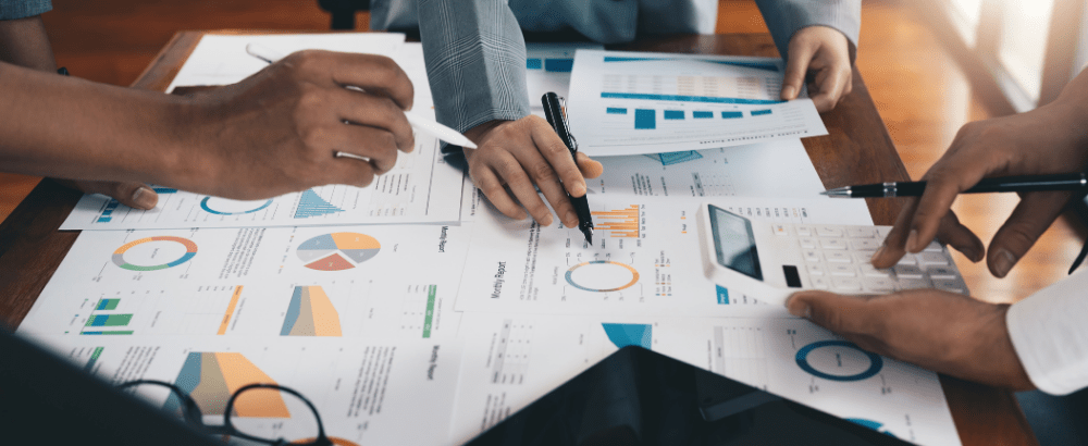 Hands are shown while working on the paper charts and graphs