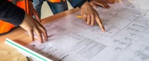 construction workers hands are kept on the design paper chart and pointing fingers on it